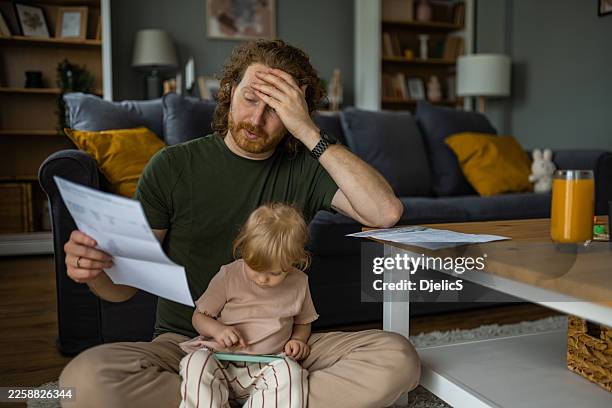 stressed father worrying about finances with daughter at home - social issues stock pictures, royalty-free photos & images