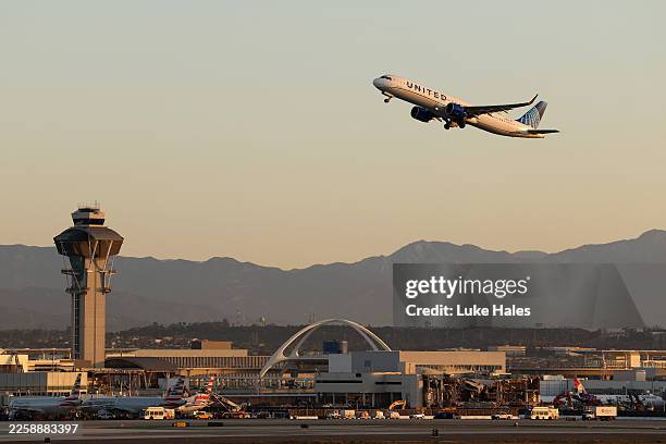 United Airlines Airbus A321-271NX takes off from Los Angeles International Airport in front of the air traffic control tower and the theme building...