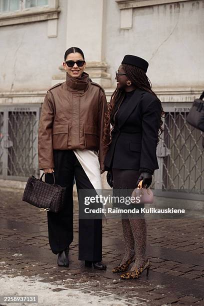 Bella Emar wears a brown leather jacket with a high collar, black wide-leg tailored trousers, black pointed-toe ankle boots, black cat-eye...