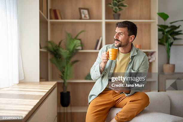 hombre bebiendo café y usando el teléfono inteligente en casa - broma pesada fotografías e imágenes de stock