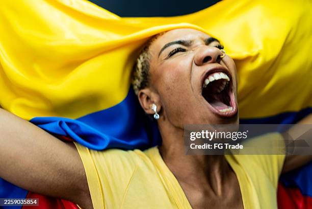 passionate colombian fan celebrating with national flag - colombian people stock pictures, royalty-free photos & images