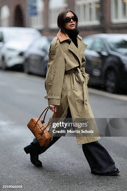 Sophia Geiss is seen wearing a long khaki green cotton-nylon trench coat with embossed Visetos monogram printed leather collar, double breasted...