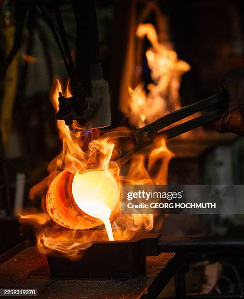 Molten gold made from jewelry is poured into a mold to produce a gold bar after it has been heated in flames at the Austrian Gold and Silver Refinery...