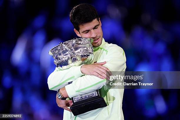 Carlos Alcaraz of Spain hugs the Norman Brookes Challenge Cup at the presentation ceremony after his victory in the Men's Singles Final against Novak...