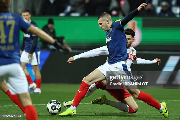Holstein Kiel's Slovenian defender David Zec and Stuttgart's German midfielder Atakan Karazor vie for the ball during the German Cup quartefinal...