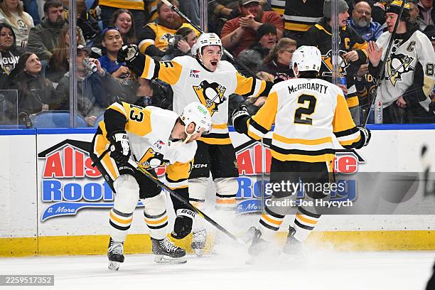 Avery Hayes of the Pittsburgh Penguins celebrates with teammates after scoring his first career goal during the first period of an NHL against the...