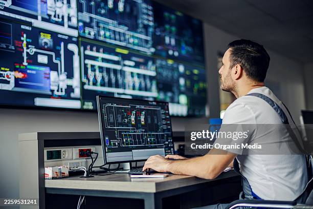 employee monitoring industrial systems in control room - elektrische voeding stockfoto's en -beelden