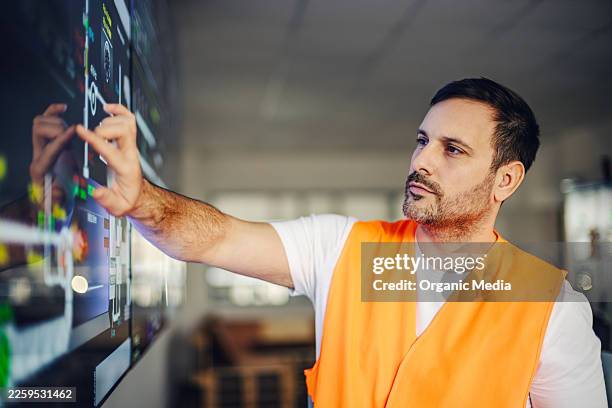 engineer controlling industrial process on interactive screen - monitoring equipment stock pictures, royalty-free photos & images