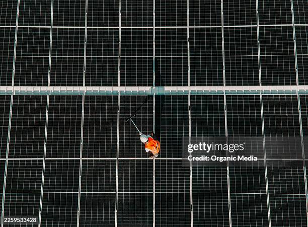 worker cleaning solar panel system for renewable energy - energy storage stock pictures, royalty-free photos & images