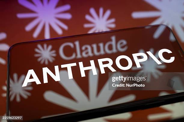 The Anthropic logo displays on the screen of a smartphone placed on a reflective surface onto which an illustration in the colors of Claude AI is...