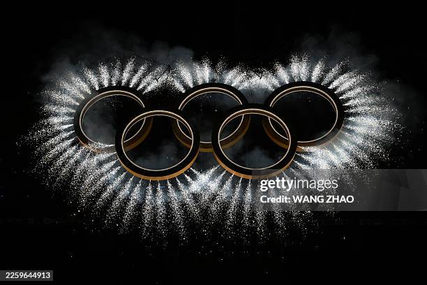 The Olympic rings surrounded by fireworks are displayed during the opening ceremony of the Milano Cortina 2026 Winter Olympic Games at the San Siro...