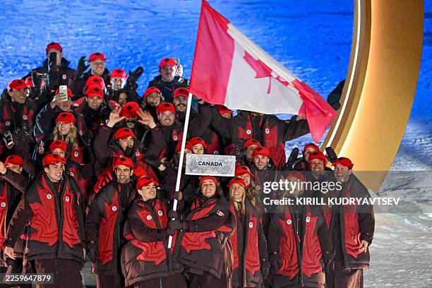 Canada's flag bearer Marielle Thompson and Mikael Kingsbury parade with their team during the opening ceremony of the Milano Cortina 2026 Winter...
