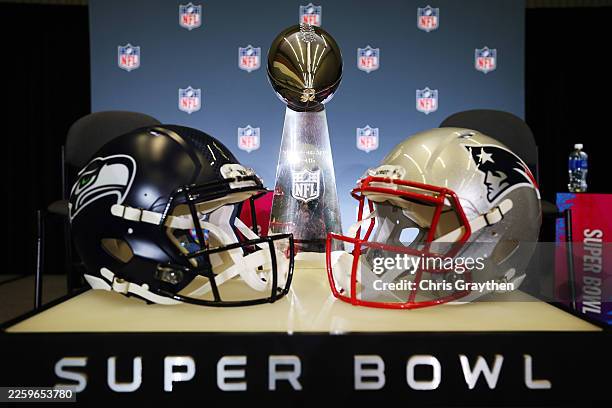 The Vince Lombardi Trophy is framed by the Seattle Seahawks and New England Patriots helmets during Super Bowl LX Opening Night at San Jose McEnery...