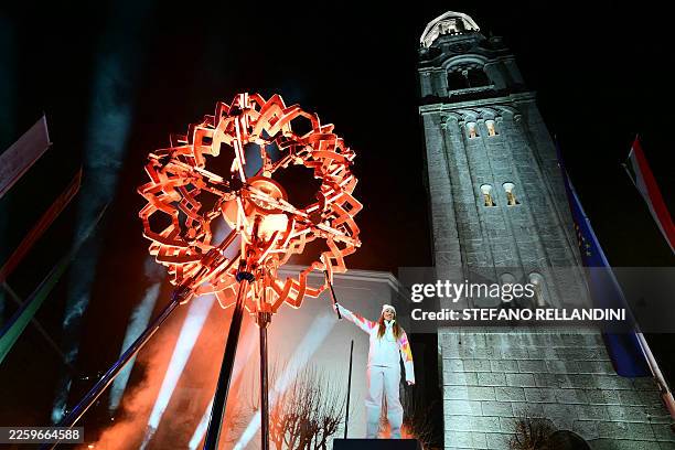 Final torchbearer Italian skier Sofia Goggia uses the torch of the Olympic flame to light the Olympic cauldron designed by Marco Balich during the...