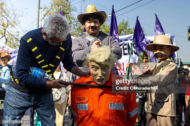 Protesters point toy guns at a person disguised with a mask of U.S. President Donald Trump during a protest in support of Nicolas Maduro outside the...