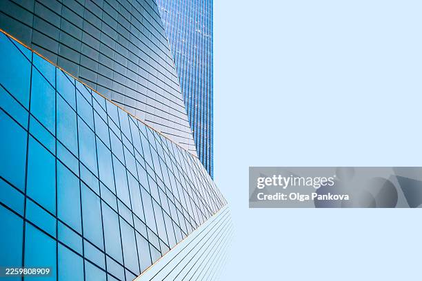 modern glass skyscraper building reflecting blue sky - wolkenkrabber stockfoto's en -beelden