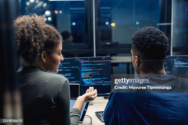 software developers engage in a collaborative code review, focusing on problem-solving and application development in a modern office environment. - verification stock pictures, royalty-free photos & images