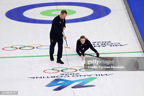Isabella Wranaa of Team Sweden throws a stone as Rasmus Wranaa of Team Sweden sweeps during a training session on day minus two of the Milano Cortina...