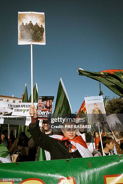 Protestor woman holding a sign with fighters during a demonstration organized by the Kurdistan diaspora and supported by left-wing political parties...