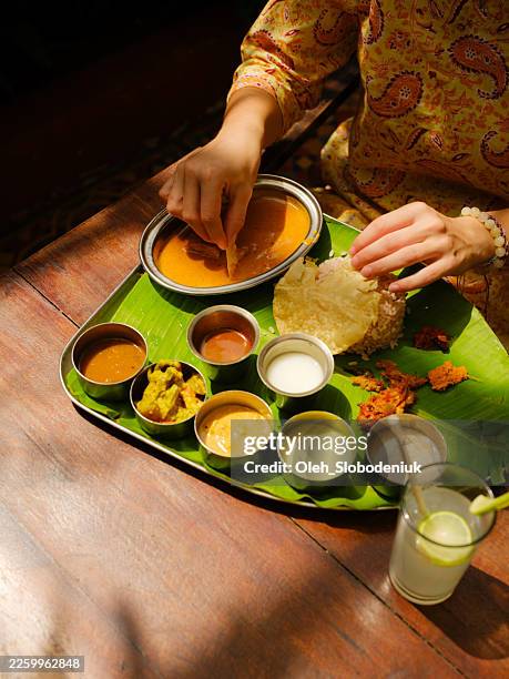 woman with banana leaf meal in kerala, india - indian food stock pictures, royalty-free photos & images