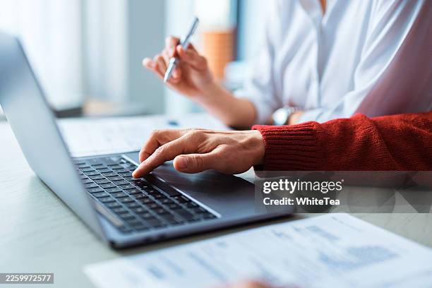 sesión de trabajo colaborativo en portátil y documentos - instrumento de escribir fotografías e imágenes de stock
