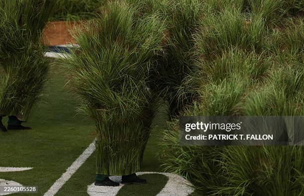 Performers dressed as Sugarcane grass step on stage for Puerto Rican singer Bad Bunny performance during Super Bowl LX Patriots vs Seahawks Apple...