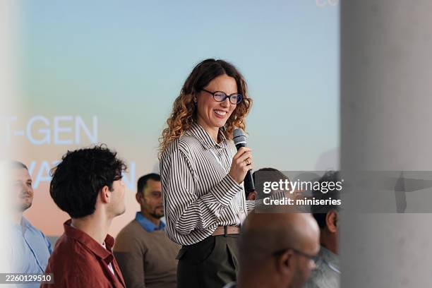 confident female speaker delivers engaging talk during professional conference forum - spokesperson stock pictures, royalty-free photos & images