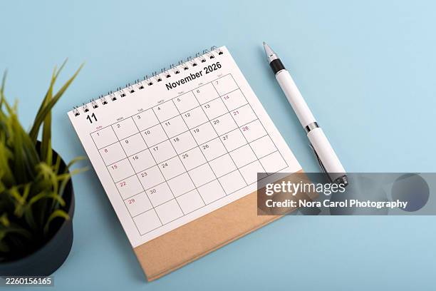 november 2026 desk calendar on blue background - november stock pictures, royalty-free photos & images