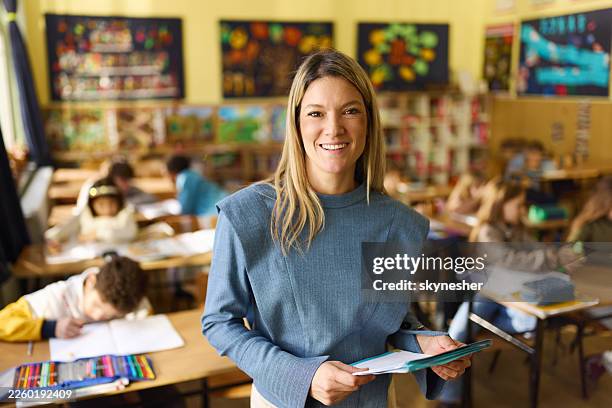 glückliche weibliche grundschullehrerin im klassenzimmer. - ausbilder stock-fotos und bilder