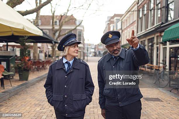 due alti ufficiali di polizia diversi in pattuglia a delft - uniforme della polizia foto e immagini stock