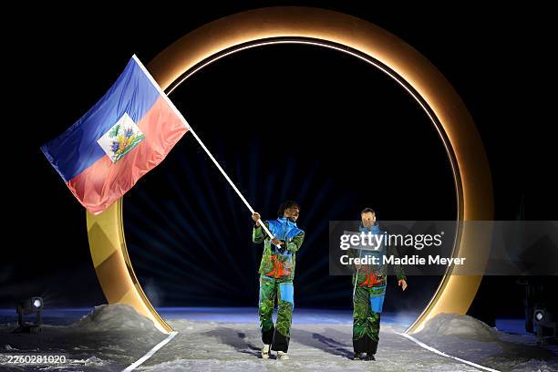 Flagbearer Stevenson Savart of Team Haiti enters with his teammate into the stadium during the opening ceremony of the Milano Cortina 2026 Winter...