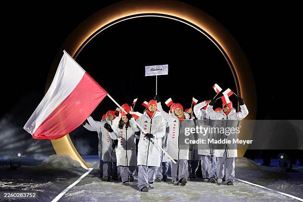 Flagbearer Kamil Stoch of Team Poland enters with the team during the opening ceremony of the Milano Cortina 2026 Winter Olympics at Predazzo Ski...