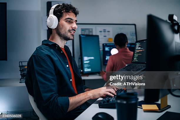 joven adulto latino y colegas programando en el ámbito tecnológico - equipo informático fotografías e imágenes de stock