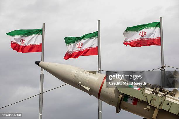 Missiles produced by Iran's armed forces are displayed near a row of Iranian flags during commemorations to mark the anniversary of the 1979 Iranian...