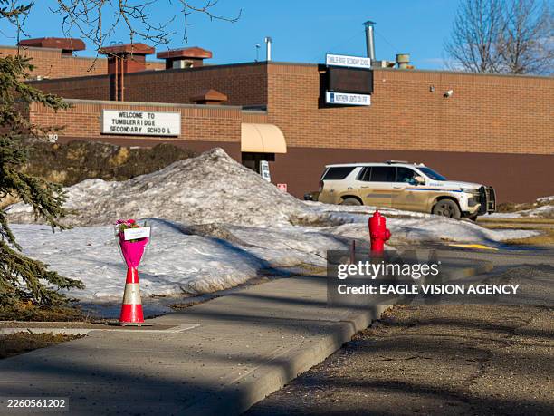 Flowers are left outside of Tumbler Ridge secondary school building where a shooting took place, leaving at least nine people dead in the small town...