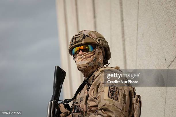 An armed member of the Islamic Revolutionary Guard Corps monitors an area while standing guard during a pro-government rally in Azadi Square in...