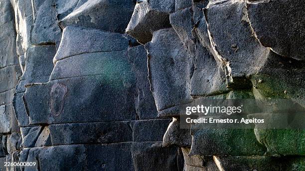 dark basalt rock formation showing natural textured surface - rock face stock pictures, royalty-free photos & images