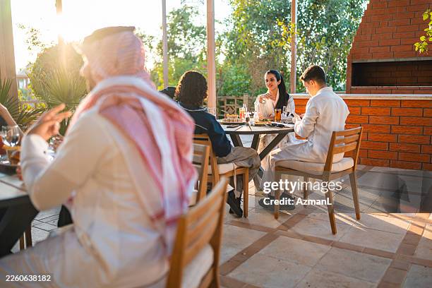 arab family enjoying dinner on outdoor restaurant patio (hotel family) - brick patio stock pictures, royalty-free photos & images