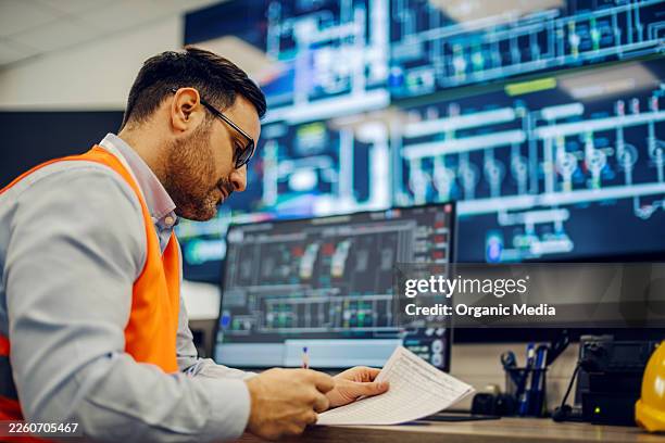 engineer monitoring industrial control room processes and data - kontrollrum bildbanksfoton och bilder