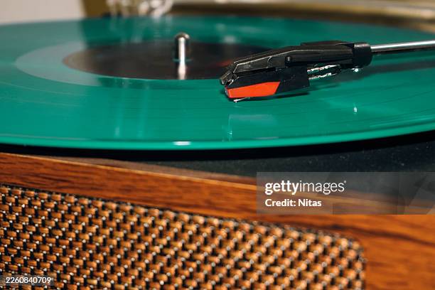 turntable playing green vinyl record enjoying vintage music - gramophone stock pictures, royalty-free photos & images