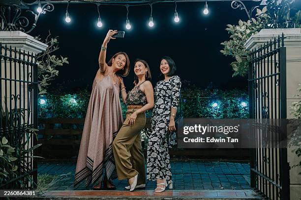 cheerful group of 3 beautiful asian women taking selfie at night outdoor party - gala stock pictures, royalty-free photos & images
