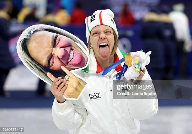 Arianna Fontana of Team Italy poses for a photo with her gold medal and a face mask of herself after the medal ceremony for the Short Track Speed...