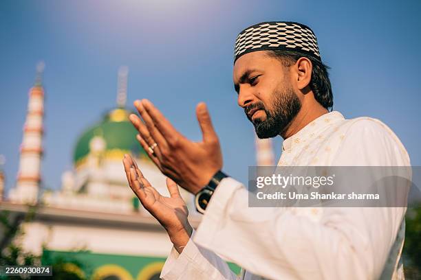muslim man offering dua prayer during ramadan near mosque in india - eid ul fitr stock pictures, royalty-free photos & images