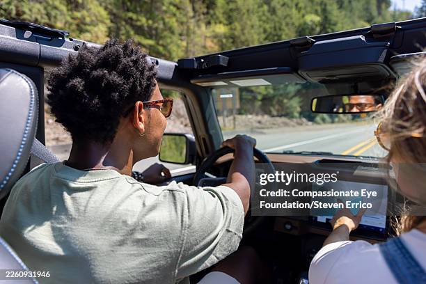 couple enjoying road trip in convertible car - on the move stock pictures, royalty-free photos & images