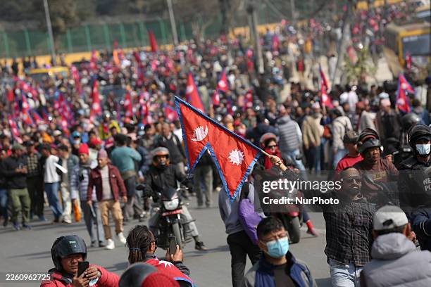Pro-monarchy supporter holds the national flag of Nepal during a gathering to welcome deposed King Gyanendra Bir Bikram Shah and his entourage to the...