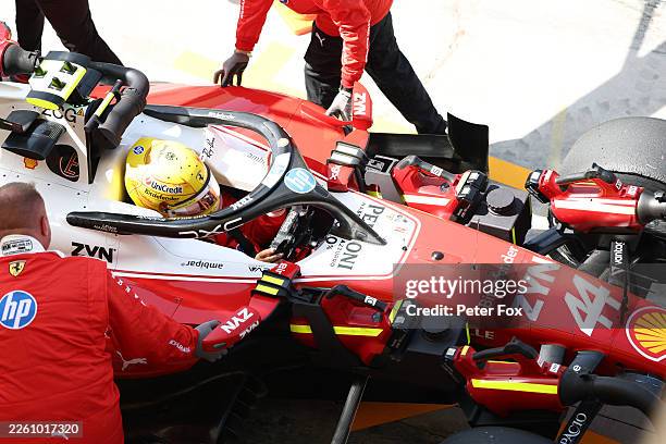 Mechanics push Lewis Hamilton of Great Britain driving the Scuderia Ferrari SF-26 back into the garage during day one of F1 Testing at Bahrain...