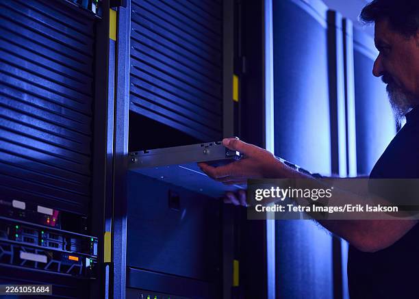 man working in data center - inserting stock pictures, royalty-free photos & images
