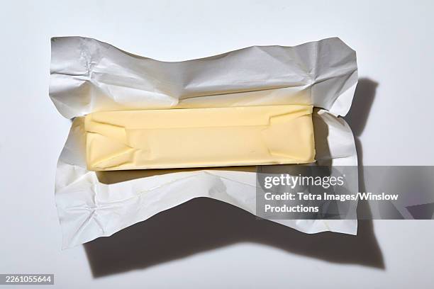 overhead view of stick of butter on white background - butter stock pictures, royalty-free photos & images