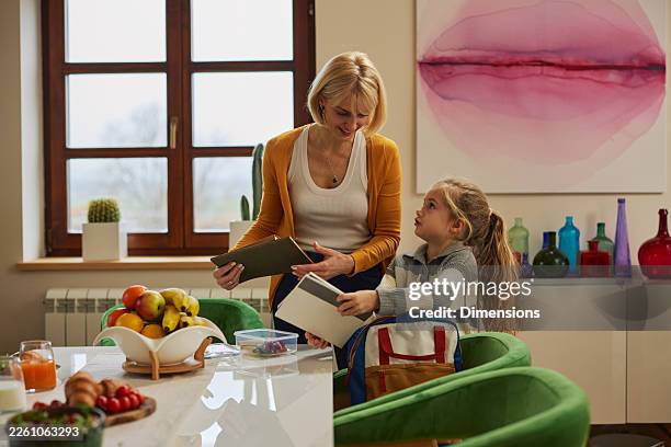 maman et fille planifiant une journée scolaire ensemble à la maison, partageant un moment de préparation et d’apprentissage - chambre bien rangée photos et images de collection