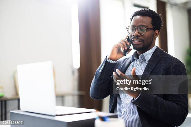 young adult man having business phone call discussing work - sales executive stock pictures, royalty-free photos & images